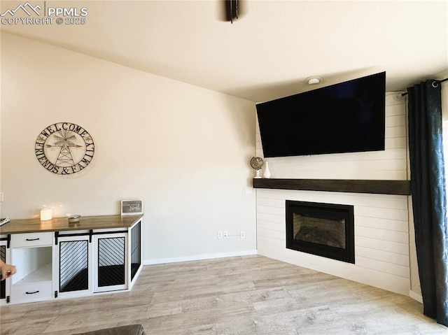 unfurnished living room featuring light wood-type flooring and a fireplace