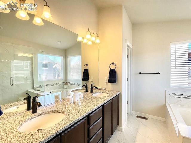 bathroom with vanity and shower with separate bathtub