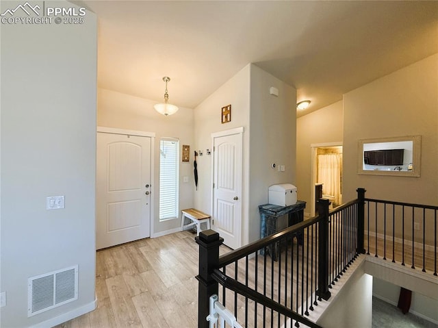 entryway featuring light hardwood / wood-style floors and vaulted ceiling