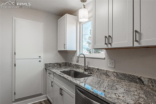 kitchen featuring pendant lighting, sink, dishwasher, light stone countertops, and white cabinets