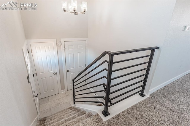 staircase featuring a notable chandelier and carpet