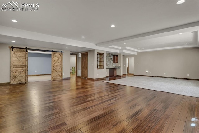 interior space featuring a barn door, hardwood / wood-style floors, and a tray ceiling