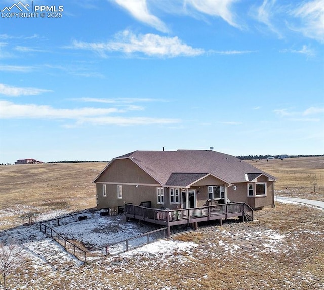 snow covered property with a rural view and a deck