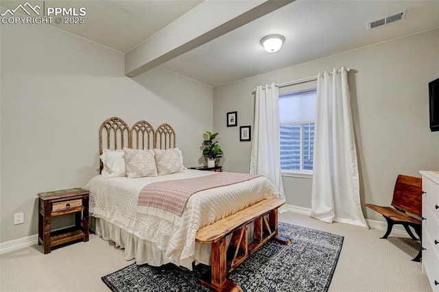 carpeted bedroom with beam ceiling