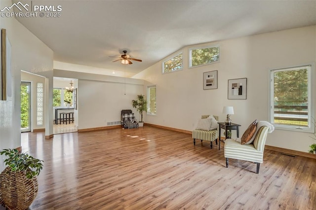 sitting room featuring lofted ceiling, ceiling fan with notable chandelier, and light hardwood / wood-style floors