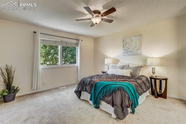 bedroom featuring ceiling fan, a textured ceiling, and carpet