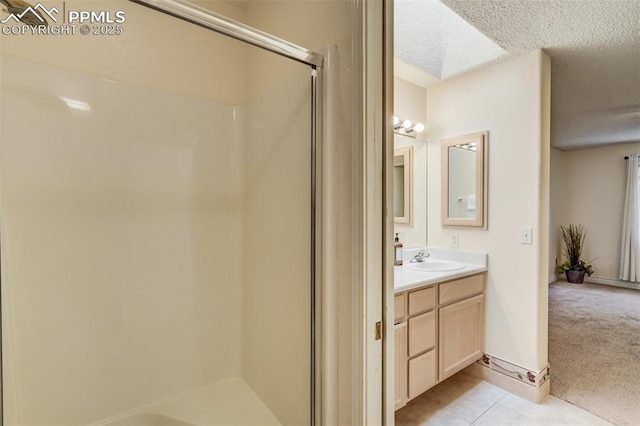 bathroom featuring walk in shower, vanity, tile patterned flooring, and a textured ceiling