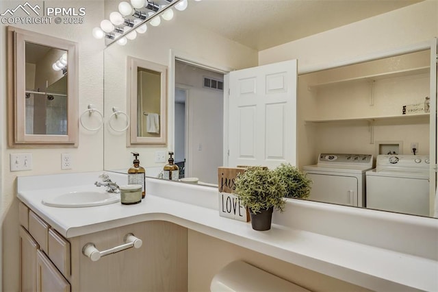 bathroom featuring vanity and separate washer and dryer