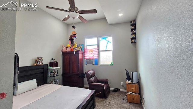 carpeted bedroom with ceiling fan, a textured wall, and baseboards