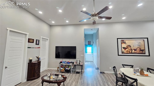 living area featuring a ceiling fan, recessed lighting, baseboards, and wood finished floors