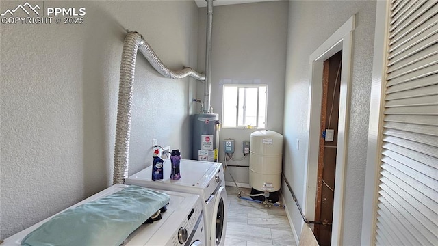 washroom featuring laundry area, washer and clothes dryer, gas water heater, and a textured wall