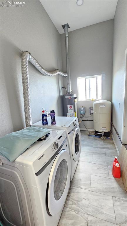 clothes washing area with washing machine and dryer, laundry area, electric water heater, and marble finish floor