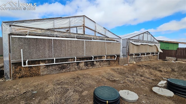 exterior space featuring an outdoor structure and fence