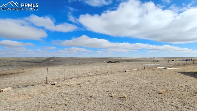 view of yard with fence and a rural view