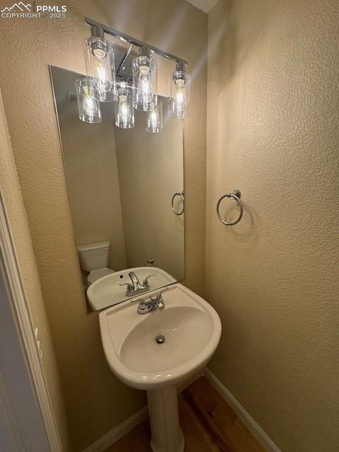 bathroom with hardwood / wood-style floors and toilet