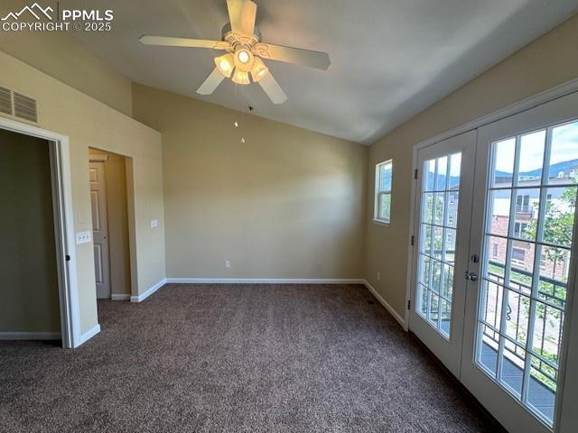 carpeted empty room featuring lofted ceiling, ceiling fan, and french doors