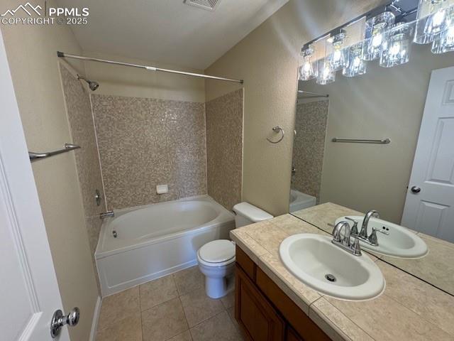 full bathroom featuring vanity, tile patterned floors, toilet, and tiled shower / bath