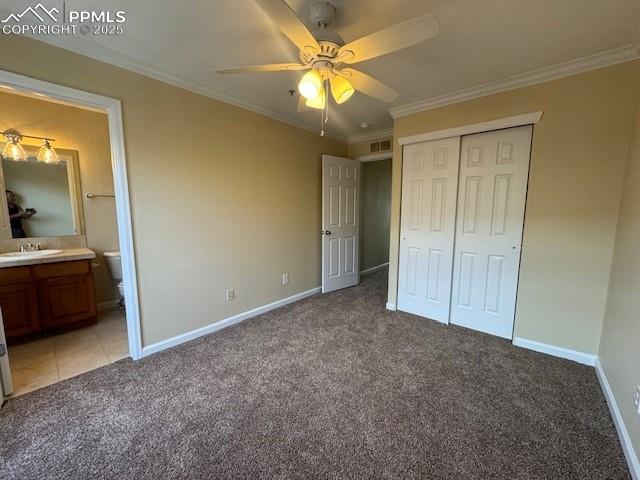 unfurnished bedroom featuring crown molding, light colored carpet, and a closet