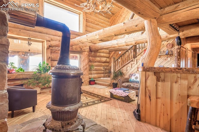 interior space with a high ceiling, wood-type flooring, a healthy amount of sunlight, and rustic walls