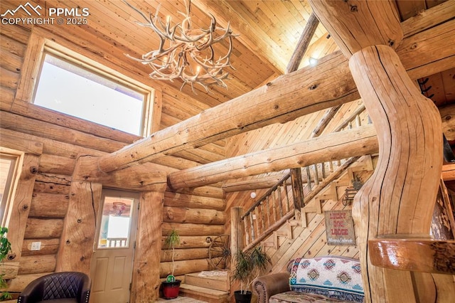 interior space with beam ceiling, wooden ceiling, rustic walls, and a chandelier