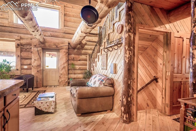 living room with wooden ceiling, log walls, light wood-type flooring, and a wealth of natural light