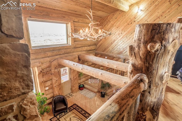 stairs with rustic walls, a chandelier, hardwood / wood-style flooring, wood ceiling, and beam ceiling