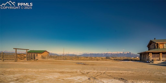 view of yard featuring a rural view, a mountain view, and an outbuilding