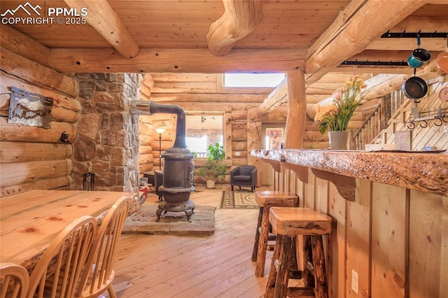 bar with beamed ceiling, wood-type flooring, a wood stove, and wood ceiling