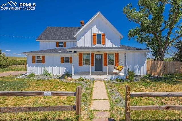 modern inspired farmhouse featuring covered porch and a front lawn