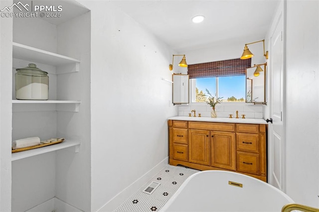 bathroom with a bathing tub, vanity, and decorative backsplash