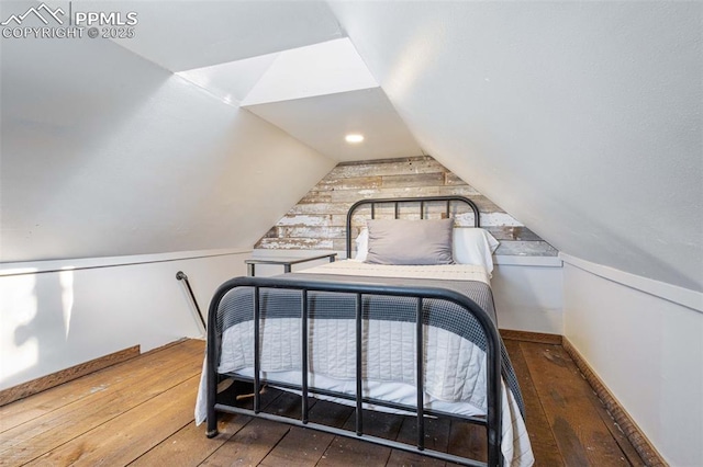 bedroom featuring dark wood-type flooring and vaulted ceiling