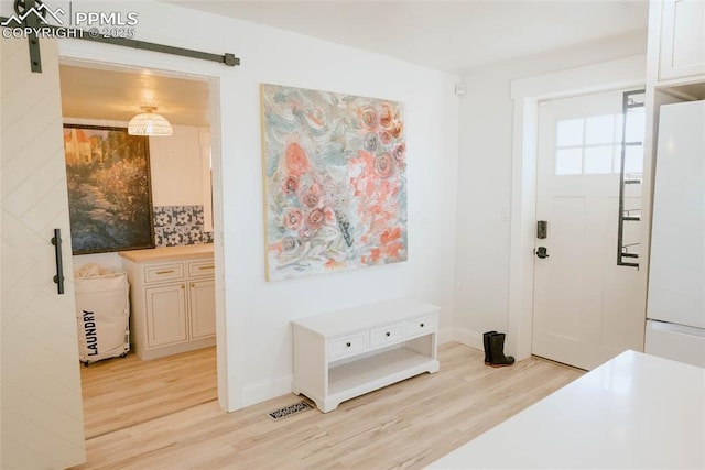 foyer with light hardwood / wood-style flooring and a barn door