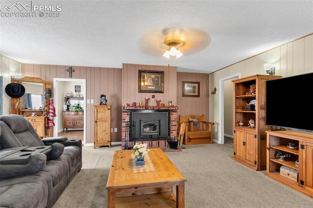 living room featuring a wood stove, light carpet, and a textured ceiling