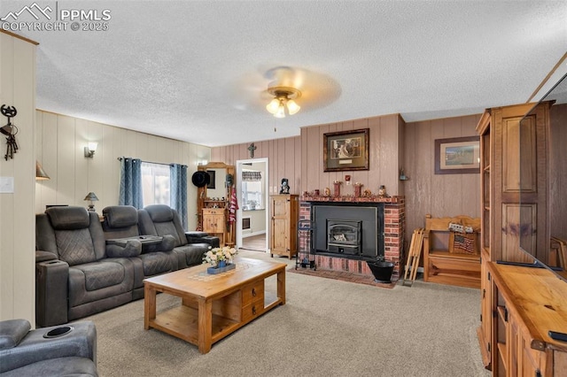 carpeted living room featuring ceiling fan, a textured ceiling, and a wood stove