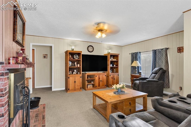 living room with a textured ceiling, a fireplace, light colored carpet, and ceiling fan