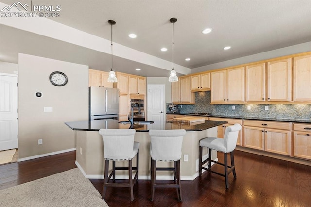 kitchen featuring stainless steel fridge, decorative light fixtures, sink, and light brown cabinets