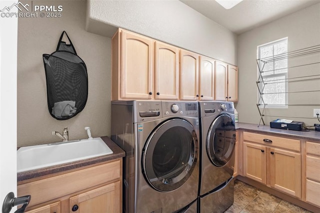 laundry room with cabinets, sink, and washer and clothes dryer