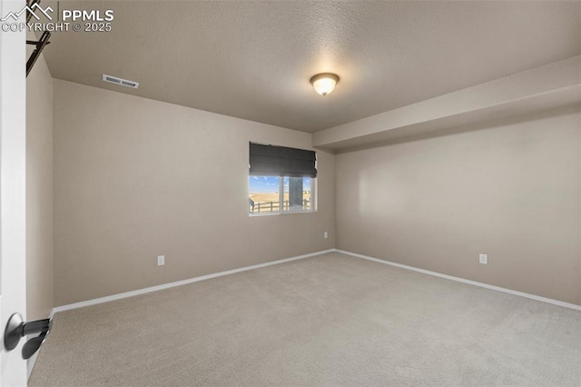 unfurnished room with carpet and a textured ceiling