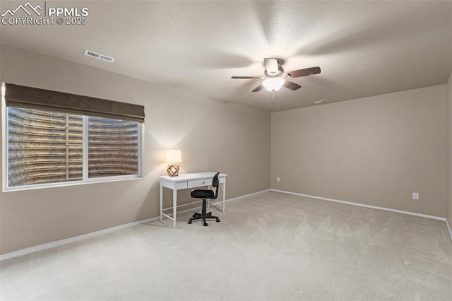 carpeted office featuring a textured ceiling and ceiling fan