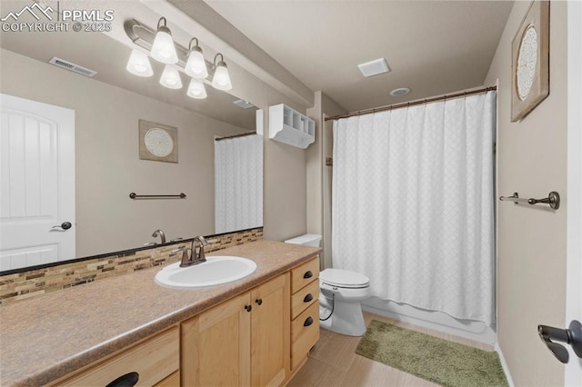 full bathroom featuring vanity, tasteful backsplash, shower / bath combination with curtain, and toilet