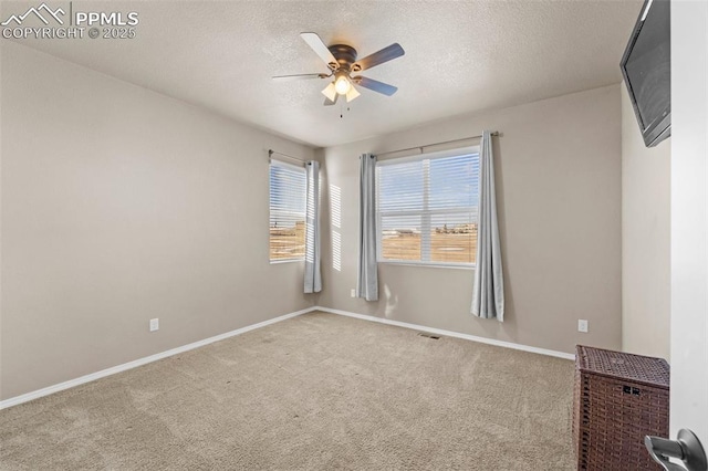 carpeted empty room featuring a textured ceiling and ceiling fan