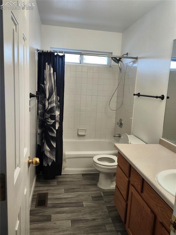 full bathroom featuring shower / bath combination with curtain, vanity, toilet, and wood-type flooring