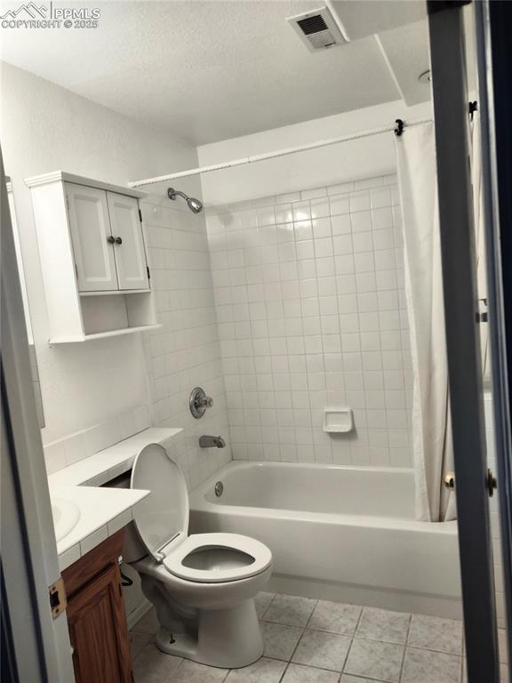 full bathroom featuring vanity, shower / tub combo with curtain, tile patterned floors, and toilet