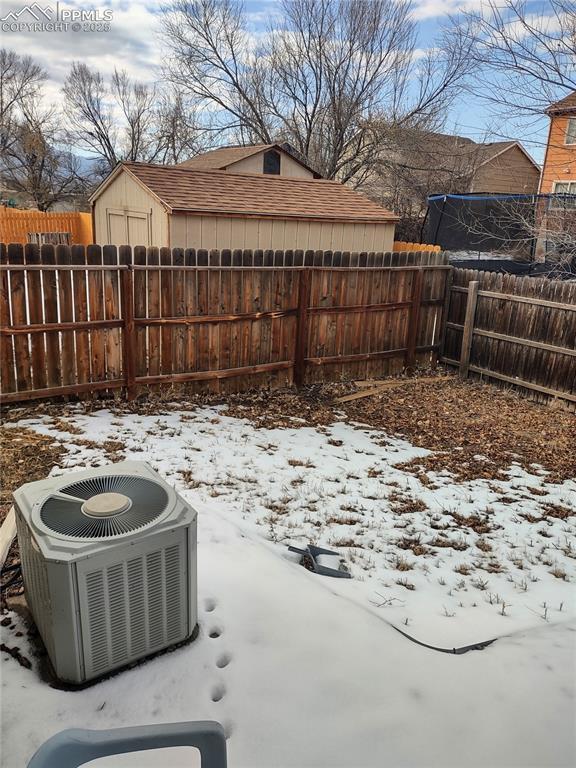 snow covered patio with cooling unit