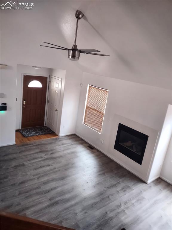 unfurnished living room with dark hardwood / wood-style flooring and high vaulted ceiling