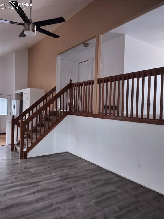 staircase with hardwood / wood-style floors, vaulted ceiling, and ceiling fan