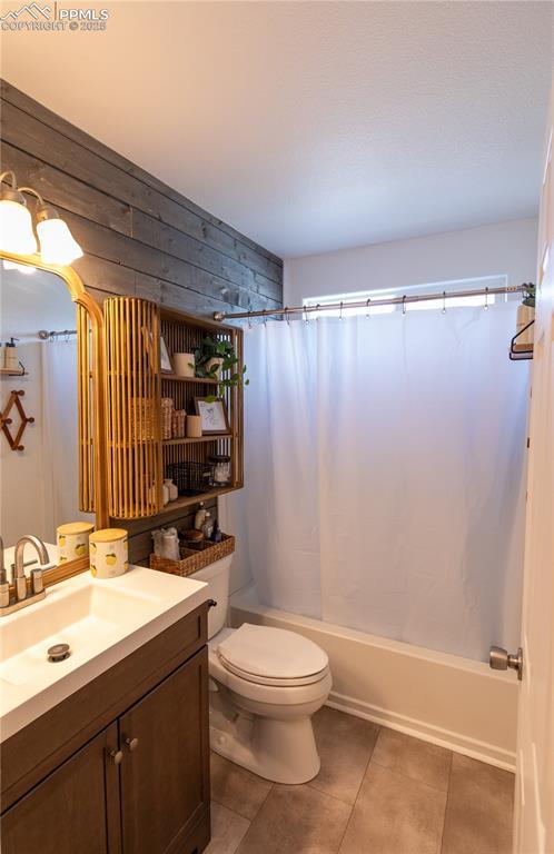 full bathroom with vanity, shower / tub combo, tile patterned flooring, and toilet