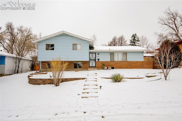 view of snow covered back of property