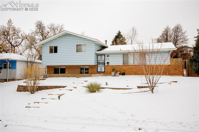 view of snow covered back of property