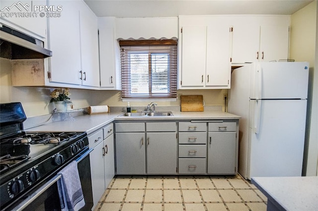 517 W Ramona Ave, Colorado Springs, CO 80905 - kitchen with white refrigerator, white cabinetry, black gas stove, and sink